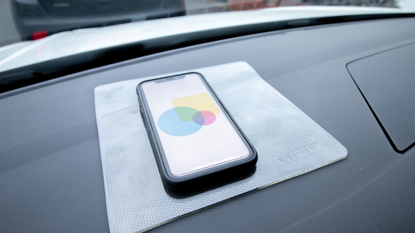 extreme grip on dashboard of car, cell phone on top